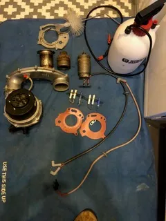 Boiler repair parts laid out including fan assembly, seals, and gaskets before refit
