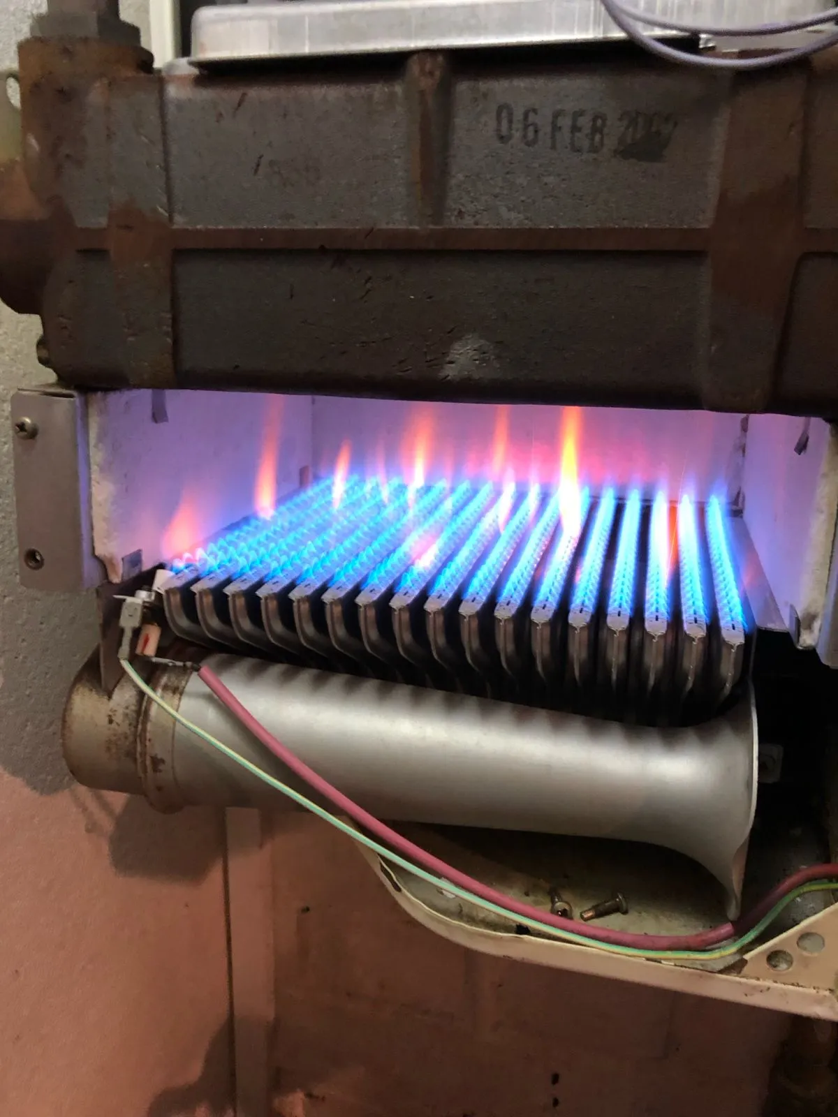 Gas boiler burner with blue flames during inspection – efficient combustion by AC Plumbers Ltd. Brighton