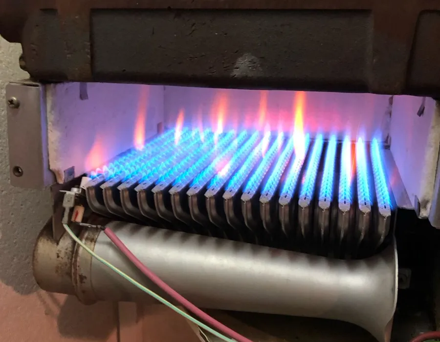Gas boiler burner with blue flames during inspection – efficient combustion by AC Plumbers Ltd. Brighton