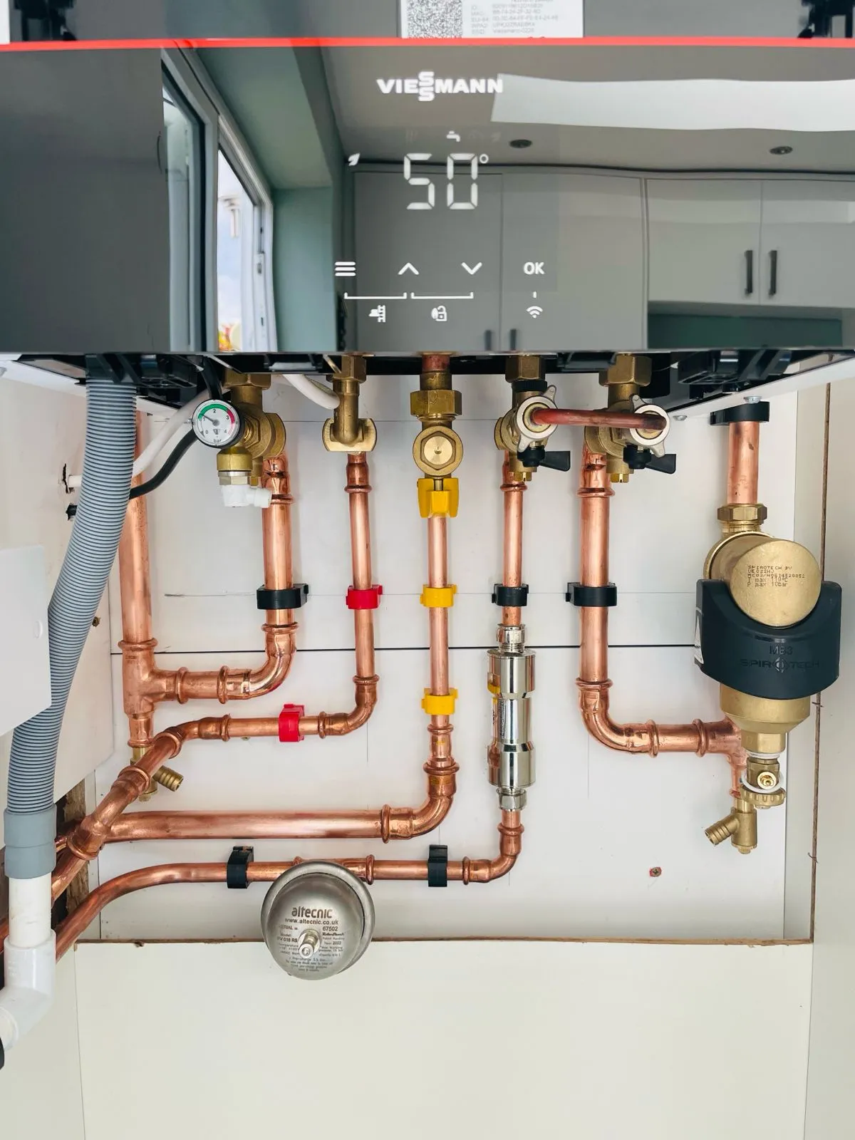 Close-up of Viessmann boiler controls and copper pipe installation with magnetic filter