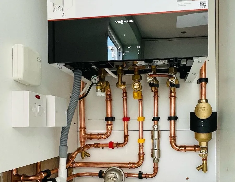 Viessmann boiler installation with labelled copper pipework and Altecnic pressure gauge inside utility unit